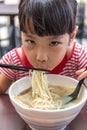 Asian little Chinese girl eating noodles soup Royalty Free Stock Photo