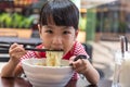 Asian little Chinese girl eating noodles soup Royalty Free Stock Photo