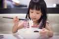 Asian little Chinese girl eating noodles soup Royalty Free Stock Photo