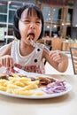 Asian Little Chinese Girl Eating Western Food Royalty Free Stock Photo