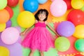 Asian Little Chinese Girl Lying on the Floor amongst Colorful Ba Royalty Free Stock Photo