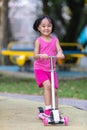 Asian little Chinese girl playing with scooter Royalty Free Stock Photo