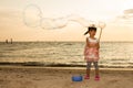 Asian Little Chinese Girl Playing Soap Bubbles on the Beach Royalty Free Stock Photo