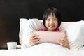 Asian Little Chinese Girl playing tablet in bed Royalty Free Stock Photo