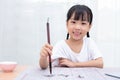 Asian little Chinese girl practice Chinese calligraphy Royalty Free Stock Photo