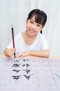 Asian little Chinese girl practice Chinese calligraphy Royalty Free Stock Photo