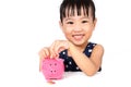 Asian Little Chinese Girl Putting Coins into Piggy Bank Royalty Free Stock Photo