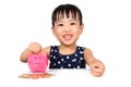 Asian Little Chinese Girl Putting Coins into Piggy Bank Royalty Free Stock Photo