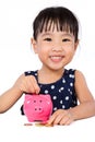Asian Little Chinese Girl Putting Coins into Piggy Bank Royalty Free Stock Photo