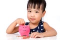 Asian Little Chinese Girl Putting Coins into Piggy Bank Royalty Free Stock Photo