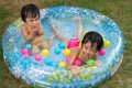 Asian Little Chinese Girls Playing in an Inflatable Rubber Swimming Pool Royalty Free Stock Photo