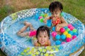 Asian Little Chinese Girls Playing in an Inflatable Rubber Swimming Pool Royalty Free Stock Photo