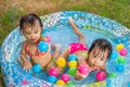 Asian Little Chinese Girls Playing in an Inflatable Rubber Swimming Pool Royalty Free Stock Photo