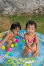 Asian Little Chinese Girls Playing in an Inflatable Rubber Swimming Pool Royalty Free Stock Photo