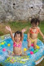 Asian Little Chinese Girls Playing in an Inflatable Rubber Swimming Pool Royalty Free Stock Photo