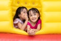 Asian Little Chinese sisters playing at inflatable castle