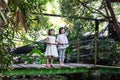 Asian Little Chinese Sisters standing on the wooden bridge