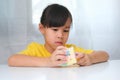 Asian little cute girl holding Rubik\'s cube in her hands and playing with it.