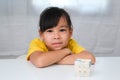 Asian little cute girl holding Rubik\'s cube in her hands and playing with it.