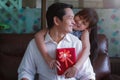 Asian little daughter congratulating dad and giving him gift box with smiling and hugging.Concept of Happy father`s day Royalty Free Stock Photo