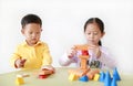 Asian little girl and baby boy playing a colorful wood block toy on table over white background. Sister and her brother playing Royalty Free Stock Photo