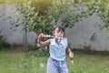 Asian little girl blowing soap bubbles in the garden. Royalty Free Stock Photo