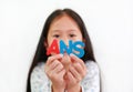 Asian little girl child holding ANS sponge text in hands over white background. Education and development concept. Focus at Royalty Free Stock Photo