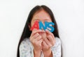 Asian little girl child holding ANS sponge text in hands over white background. Education and development concept. Focus at Royalty Free Stock Photo