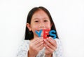 Asian little girl child holding YES sponge text in hands over white background. Education and development concept. Focus at Royalty Free Stock Photo