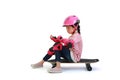 Asian little girl child skateboarder sitting on skateboard with wearing safety and protective equipment isolated on white