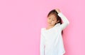 Asian little girl confused and wonder with make gesture scratching head with copy space. Uncertain with doubt, thinking with hand Royalty Free Stock Photo