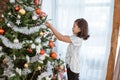 Asian little girl decorating christmas tree Royalty Free Stock Photo