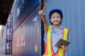 Asian little girl dress up engineering suit wearing helmet holding tablet pointing to the future.