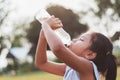 asian little girl drinking fresh water from plastic bottle with Royalty Free Stock Photo