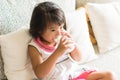 Asian little girl is drinking a milk from glass in living room Royalty Free Stock Photo