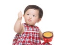 Asian little girl eating snack with thumb up Royalty Free Stock Photo