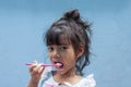 Asian little girl eating yogurt. Royalty Free Stock Photo