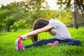 Asian little girl exercising at the outdoor park on the lawn is a meditation practice,child exercise in nature in the morning, Royalty Free Stock Photo