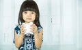 Asian little girl hand holding white piggy bank, learn to saving for the future concept Royalty Free Stock Photo