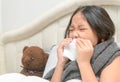 Asian little girl has runny nose and blows nose into tissue Royalty Free Stock Photo