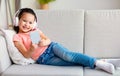 Asian Little Girl In Headphones Using Mobile Phone At Home Royalty Free Stock Photo