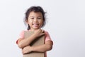 Asian little girl is hold a brown book and smiling while standing on white background Royalty Free Stock Photo
