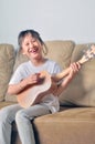 Asian little girl hold an ukulele and smiling