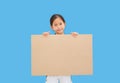 Asian little girl holding empty brown big board for media banner isolated on white background with copy space Royalty Free Stock Photo