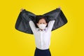 Asian little girl kid in white shirt with protective face mask taking off her formal suit and raise hand up isolated on yellow Royalty Free Stock Photo