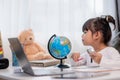 Asian little girl is learning the globe model, concept of save the world and learn through play activity for kid education at home Royalty Free Stock Photo