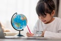 Asian little girl is learning the globe model, concept of save the world and learn through play activity for kid education at home Royalty Free Stock Photo