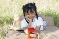 Asian little girl lying on the outdoor lawn and used mobile phone taking a selfie smile happy.