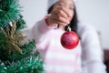 Asian little girl with mother decorating christmas tree for part