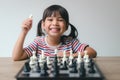 Asian little girl playing chess at home.a game of chess Royalty Free Stock Photo